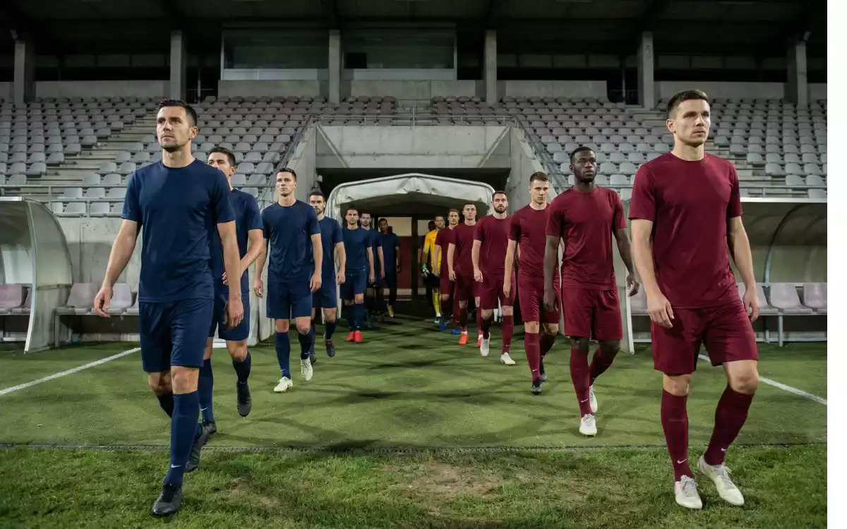 Two football teams walking onto the pitch before a European night match