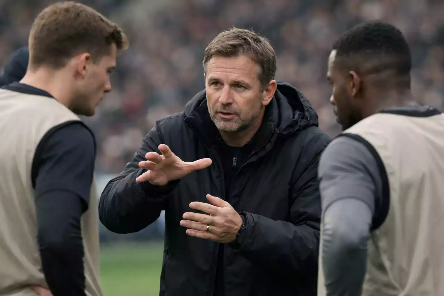 Football manager giving tactical instructions to players on the sideline